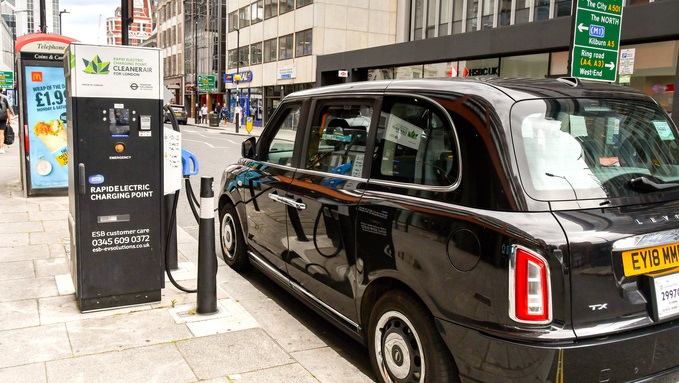 Electric London black cab connected to a rapid charging point in central London